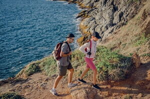 Wanderer erkunden einen felsigen Küstenwanderweg auf Lefkada – ein Highlight des Outdoor-Abenteuertourismus